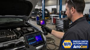 Mechanic using AI-powered thermal imaging and diagnostic tablet to detect a car AC refrigerant leak inside Gregg Smith Automotive