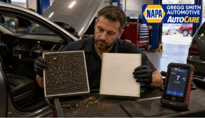 Mechanic inside Gregg Smith Automotive comparing a dirty cabin air filter with a clean bio-based filter while testing air quality
