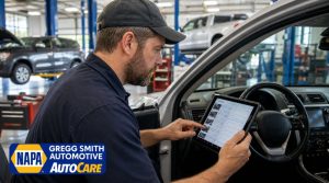 Mechanic inside a car using a tablet to review digital AC service records in Gregg Smith Automotive